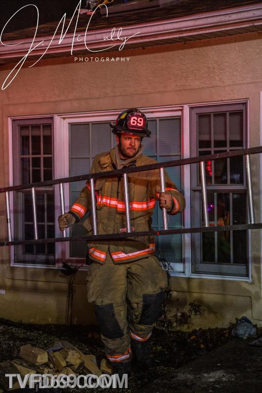 Firefighter Shirk with a  roof ladder