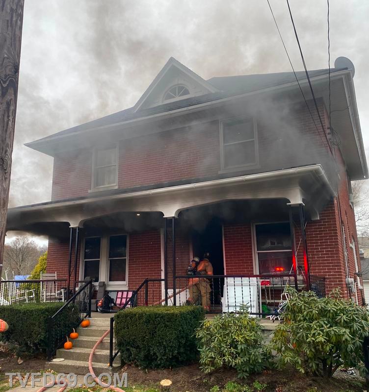 Smoke billows from the home as Firefighters make initial entry